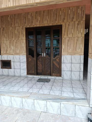 a pair of wooden doors on a building at Casa em Itapema in Itapema