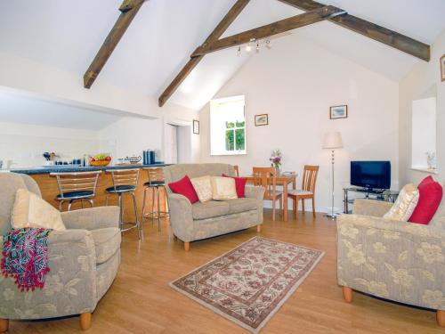 ein Wohnzimmer mit Sofas und eine Küche in der Unterkunft Lower Bushford Cottage in Talbenny