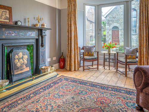 a living room with a fireplace and a table at Galeri Harlech Townhouse in Harlech