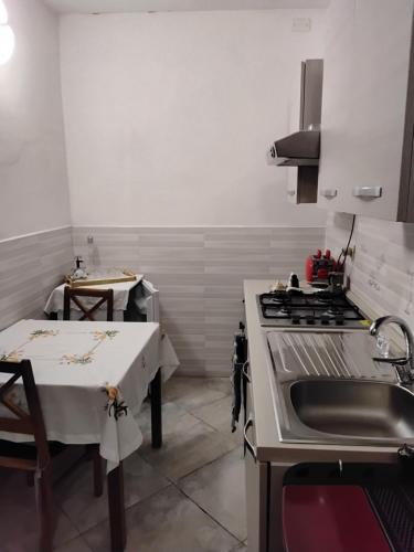 a kitchen with a stove and a sink and a table at B&B Oasi di pace in Rocca deʼGiorgi