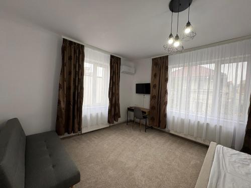 a living room with a couch and two windows at Vila Ada in Bucharest