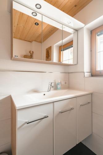 a bathroom with a sink and a mirror at Westendorf Alpen Lodge in Westendorf