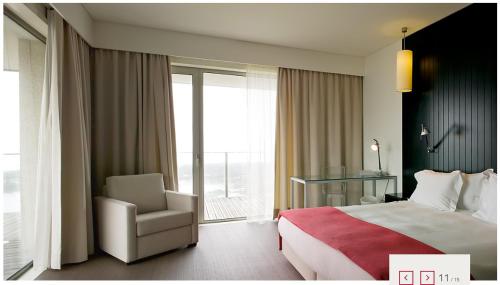 a hotel room with a bed and a chair and a window at Hotel Flor De Sal in Viana do Castelo