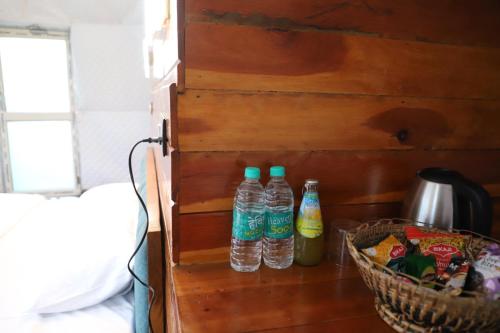 two bottles of water are on a wooden wall at The Kamcha Geodesic dome & Homestay in Bomdila