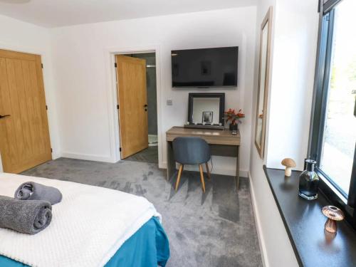 a bedroom with a bed and a desk with a television at Oaktree Cottage - 3 Bedrooms - Sleeps 6 in Frizington