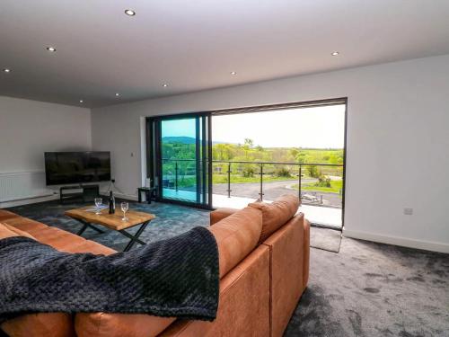 a living room with a couch and a large window at Oaktree Cottage - 3 Bedrooms - Sleeps 6 in Frizington