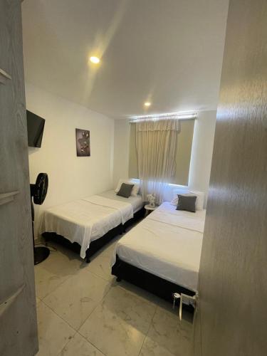 a room with two beds and a window at Suite Vista Azul Ricaurte in Ricaurte