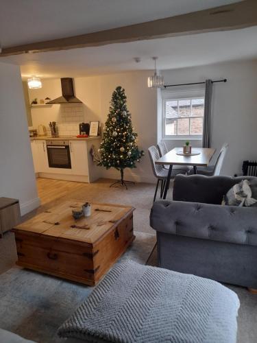 a living room with a christmas tree and a table at Ironbridge town apartment in Ironbridge