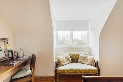 Una silla en una habitación con un escritorio y una ventana. en Cuileann, en Clarinbridge