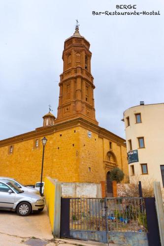 Un edificio con una torre de reloj en la parte superior. en Hostal Marcela Berge, en Berge