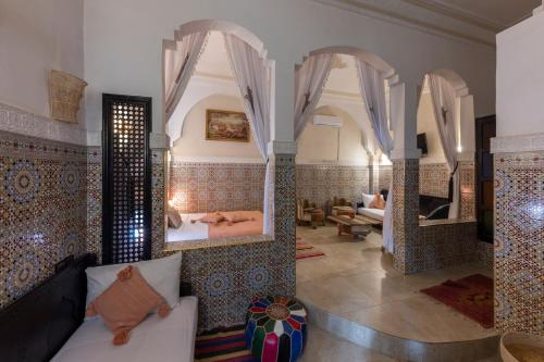 a living room with mirrors and a couch in a room at Riad Arabesque in Marrakech