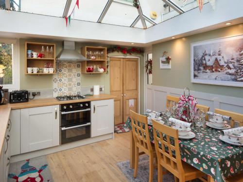 a kitchen and dining room with a table and chairs at Christmas Cottage in Cheddar
