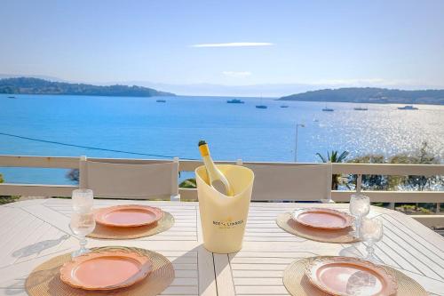 Ein Tisch mit Tellern und Weingläsern mit Blick auf das Meer in der Unterkunft Fairy home Porto Heli in Porto Heli
