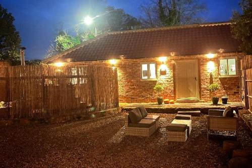 a house with a fence and a couch and chairs at Torworth - 1 Bed Barn - Sleeps 3 - Hot Tub in Torworth