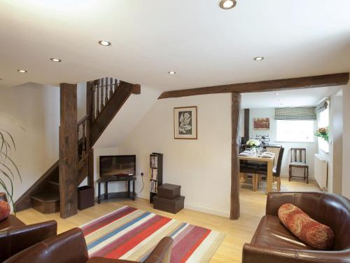 ein Wohnzimmer mit einer Couch und einer Treppe in der Unterkunft Stable Cottage - Hw7452 in Whitford