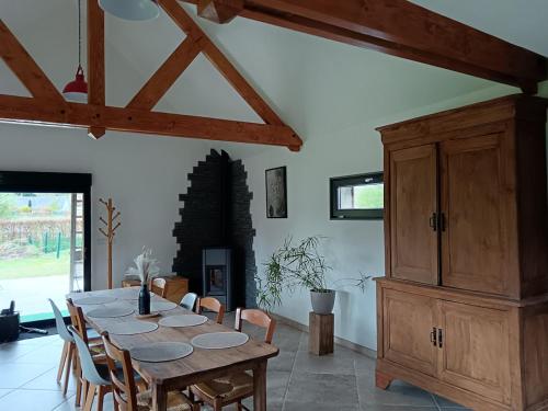 una sala da pranzo con tavolo e sedie in legno di Le gîte Normand a Saint-Vaast-dʼÉquiqueville
