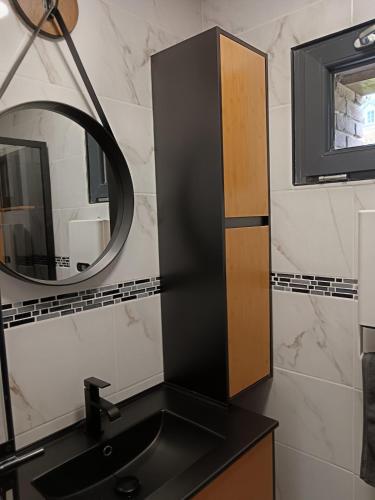 a bathroom with a black sink and a mirror at Le gîte Normand in Saint-Vaast-dʼÉquiqueville