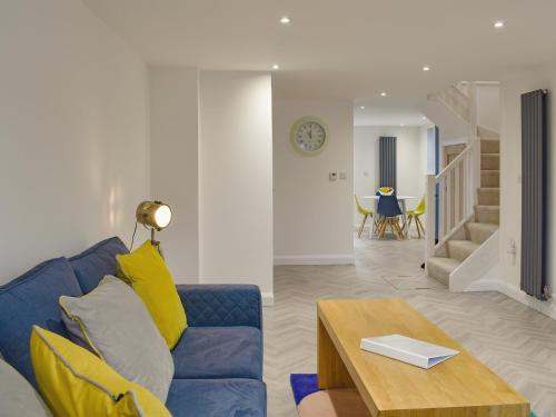 a living room with a blue couch and a table at Little Trevose in Padstow