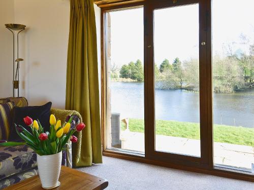 a living room with a vase of flowers on a table at Swallows Nest in Soulby