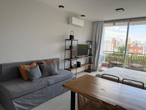 a living room with a couch and a table at Departamento Estudio Deluxe in La Plata
