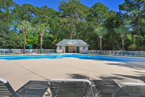 a swimming pool with chairs in front of a building at 4D Crassostrea II at True Blue Unit condo by Peace Vacations in Pawleys Island