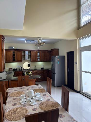 a kitchen with a table with chairs and a refrigerator at Paradise Villa in Kandana