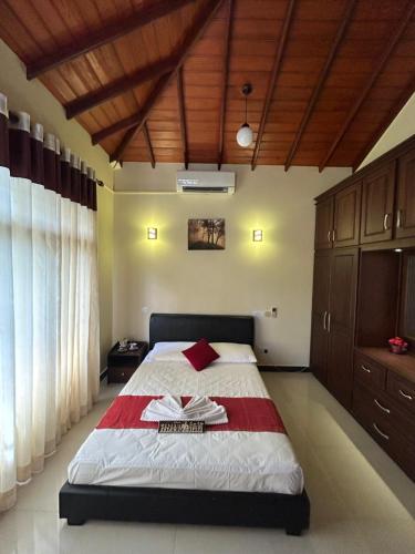 a bedroom with a bed with a red and white blanket at Paradise Villa in Kandana