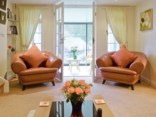 a living room with two chairs and a table at Riverside Cottage - B6859 in Saint Cleer