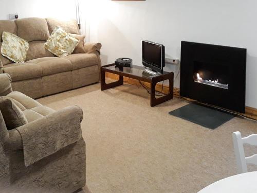 a living room with a couch and a fireplace at Jebel Kasr in Braithwaite