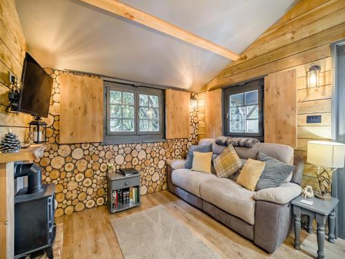 a living room with a couch and a wood wall at The Lodge - Uk50409 in Bisterne