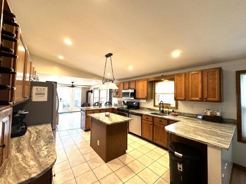 a large kitchen with wooden cabinets and a refrigerator at 20 Mile Bay Lake View 4 Bedroom Public Beach Pet Friendly fee applies in Tuftonboro