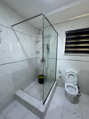 a bathroom with a shower and a toilet at Spacious and luxurious studio apartment in OguduGRA in Lagos