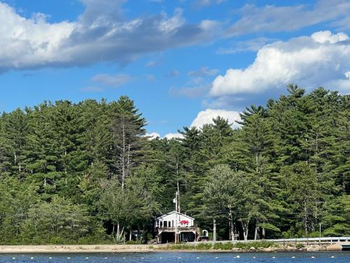a house on the shore of a lake with trees at 20 Mile Bay Lake View 4 Bedroom Public Beach Pet Friendly fee applies in Tuftonboro