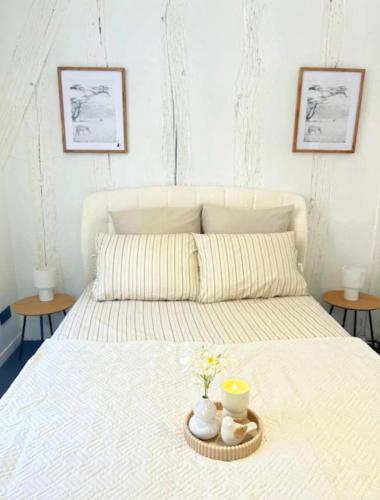 a white bed with a tray with flowers on it at Éclat du Safran - au cœur de Auxerre in Auxerre