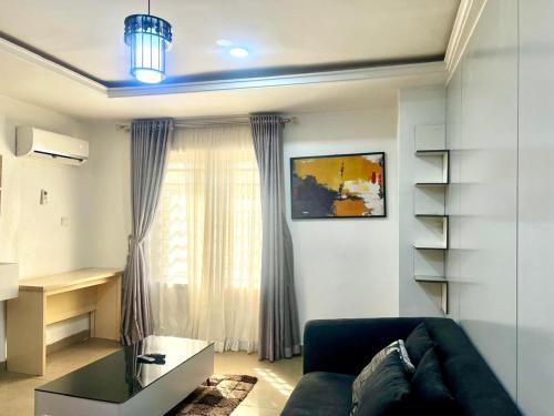 ein Wohnzimmer mit einer Couch und einem Fenster in der Unterkunft Lifecamp Apartments in Abuja