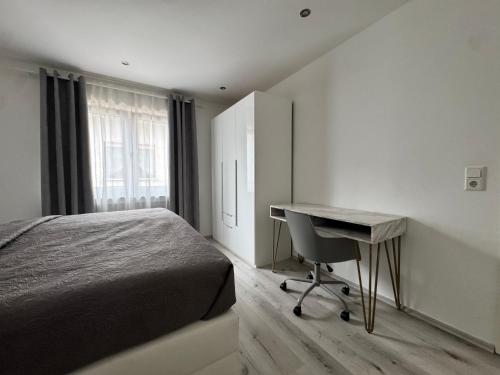 een slaapkamer met een bed en een bureau en een bureau bij Idyllische Wohnung mit Küche & Bad in Bielefeld in Bielefeld