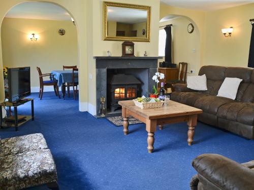 ein Wohnzimmer mit Couch und Kamin in der Unterkunft Granny Bond's Farmhouse in Buckland Brewer