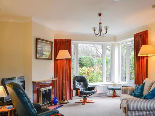 a living room with a large window with red curtains at Belgravia Cottage in Skipton