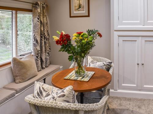 a vase of flowers on a table in a room at Uk45886 - The Studio At Cross House in Kirkby Lonsdale