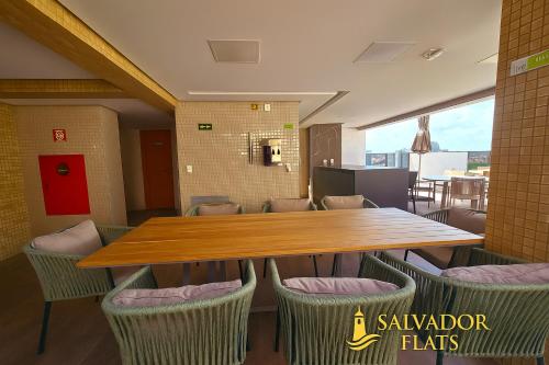 a dining room with a wooden table and chairs at Bahia Flats Facility View in Salvador