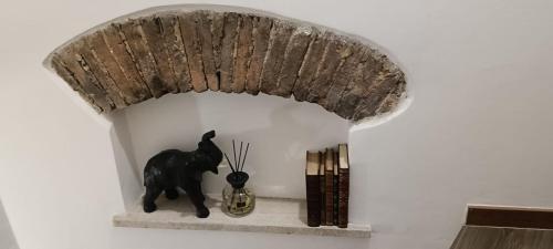 a statue of a black cat sitting on a shelf at La piazza in San Giorgio la Molara