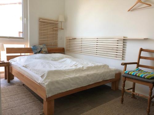 a bedroom with a large bed and two chairs at Fewo Lia in Niederdorla