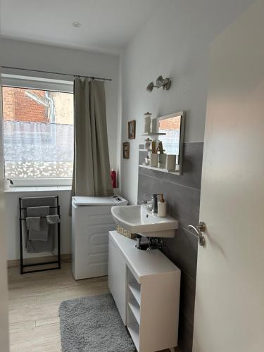 a white bathroom with a sink and a window at SleepShop in Nordhausen