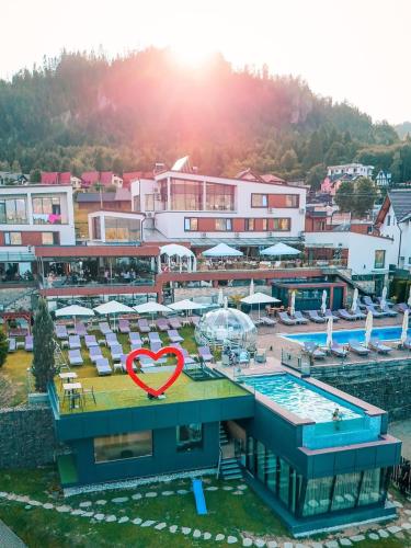 a resort with a pool with a heart sign on it at Hotel Roser House Boutique - pe malul lacului Colibita in Colibiţa