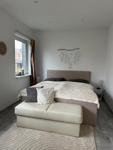 a white bedroom with a bed and a white couch at SleepShop in Nordhausen