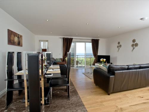 a living room with a couch and a table with chairs at Fistral View At Bredon Court in Newquay