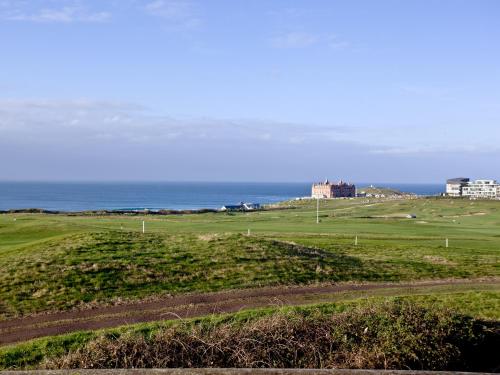 a golf course with the ocean in the background at Fistral View At Bredon Court in Newquay
