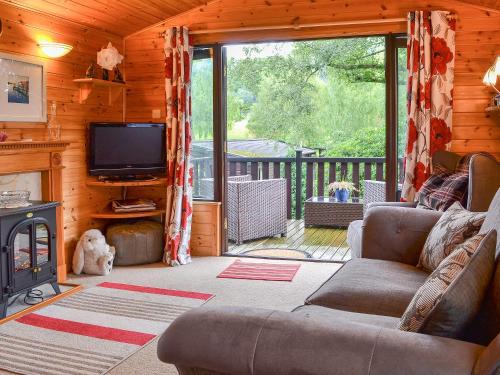 a living room with a couch and a television in a cabin at Fell View Lodge in Keswick