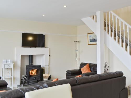 een woonkamer met een bank en een open haard bij Hedderwick House in Pittenweem