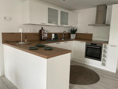 a kitchen with white cabinets and a wooden counter top at Landhaus Johann in Mürzzuschlag